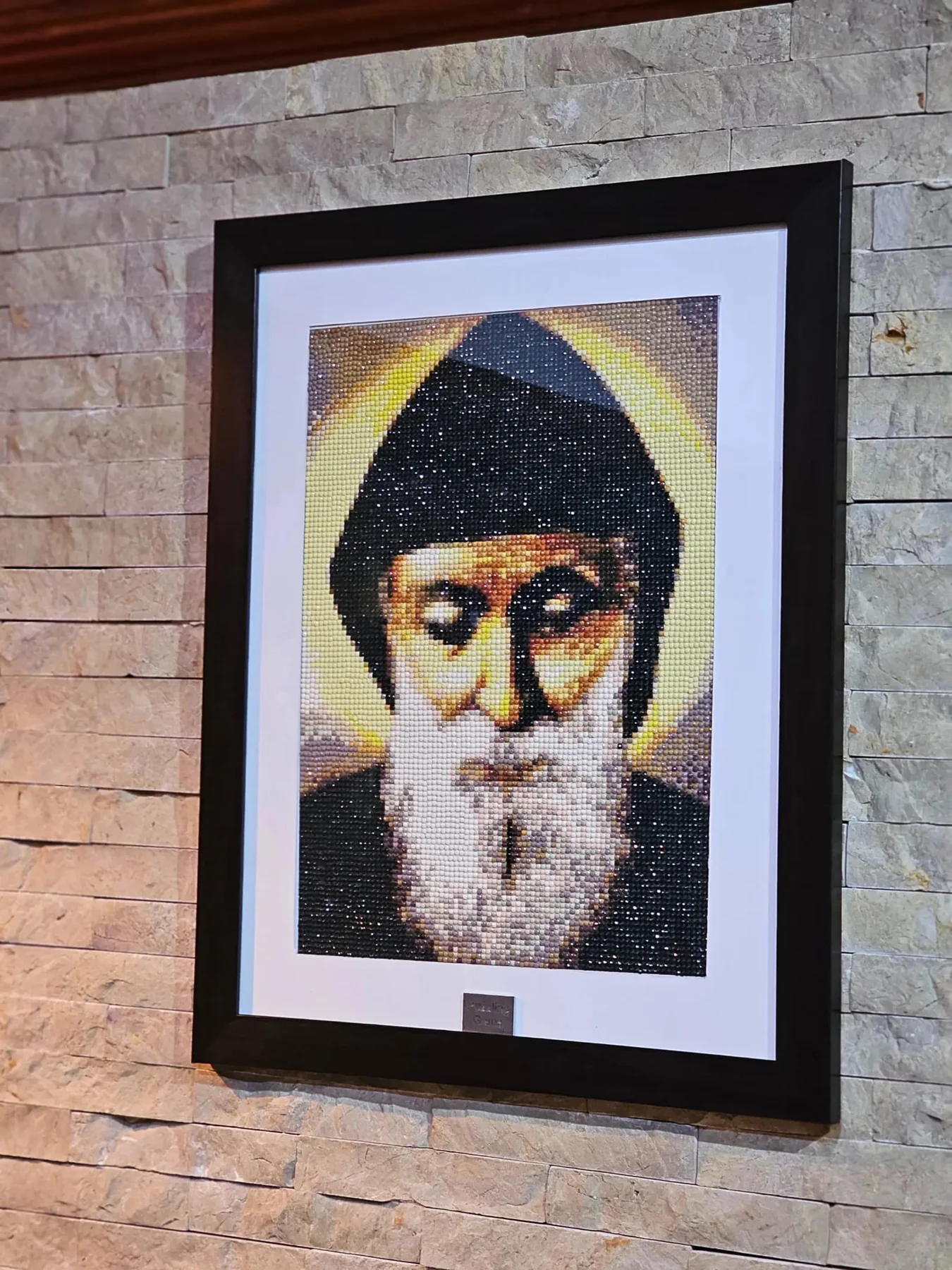Angled view of a framed Saint Charbel diamond painting portrait