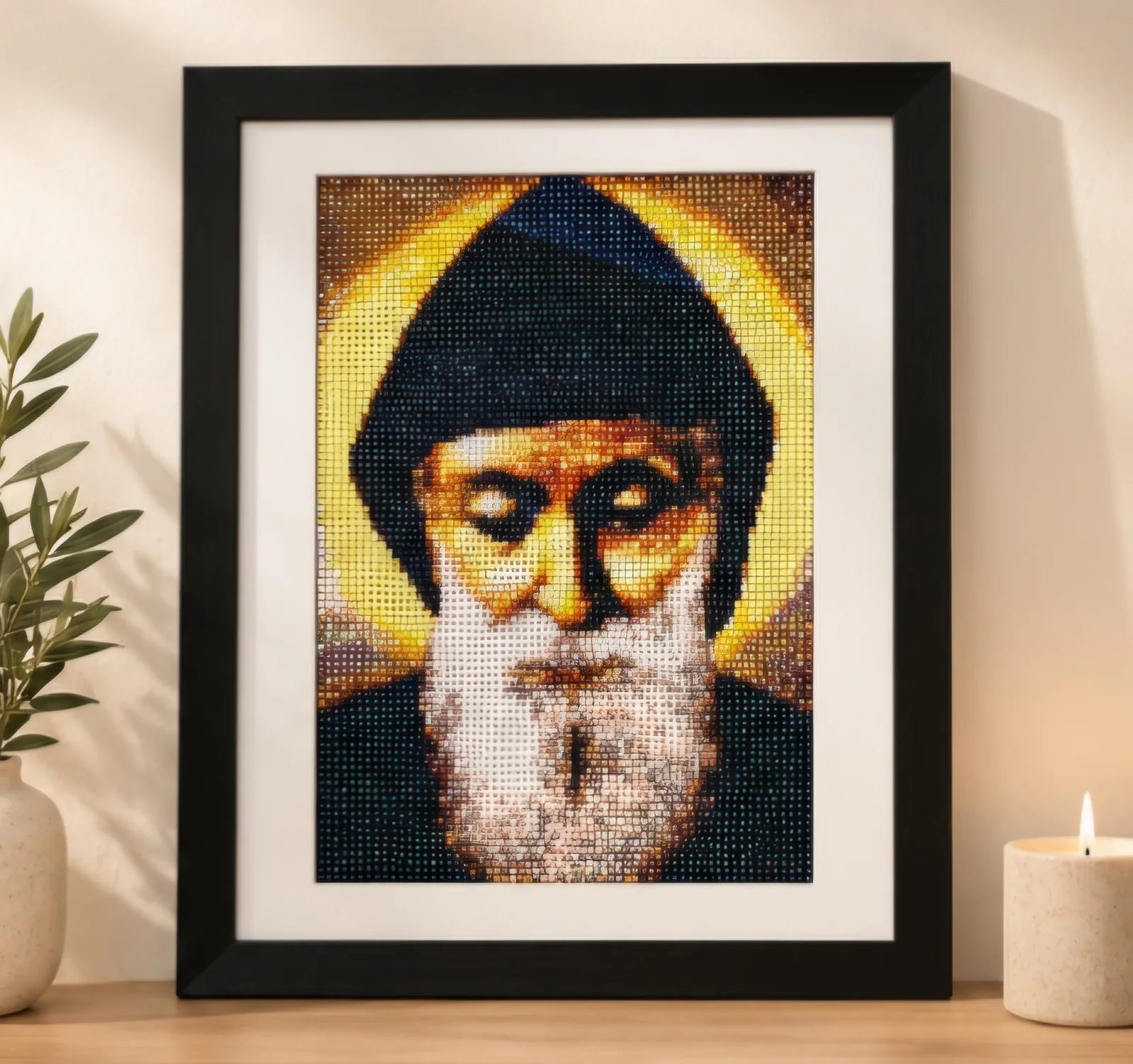 Framed Saint Charbel diamond painting portrait displayed beside a candle